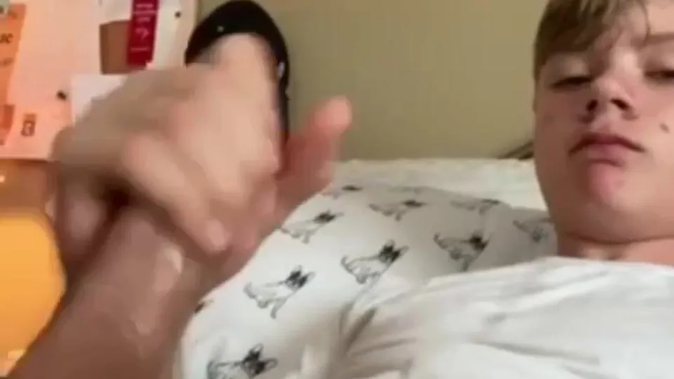 A blond twink strokes his dick and cums