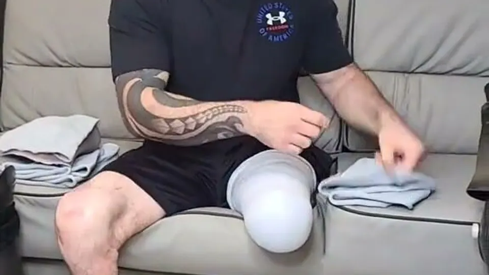 amputee adjusts prosthetic leg on couch