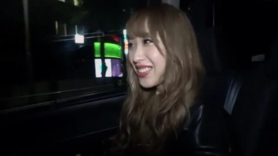 asian woman smiles in car at night