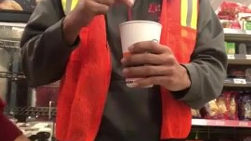 Guy in an orange high visibility safety vest coffee 1 - ThisVid.com