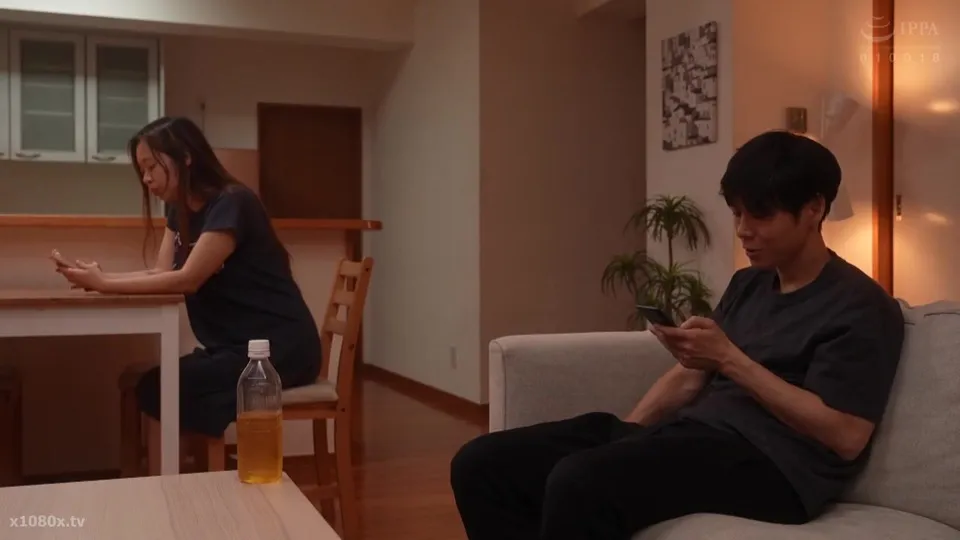young couple chats on phones in living room