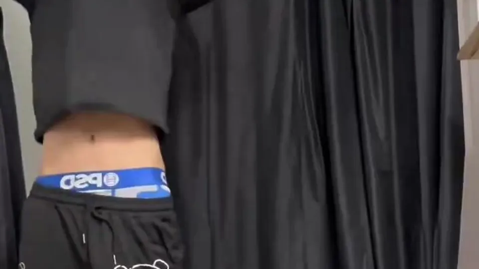 shirtless man puts on towel in bathroom