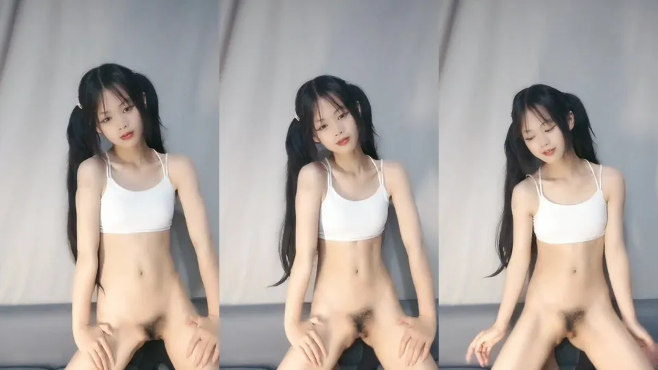 The girl with ponytails dances on the sofa 