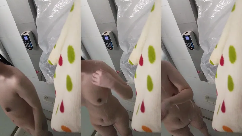 The sexy girl with glasses washes her hair and rubs her breasts and takes a selfie  