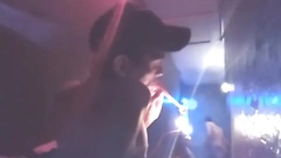 Twink in gay bathhouse smoking meth with door open.